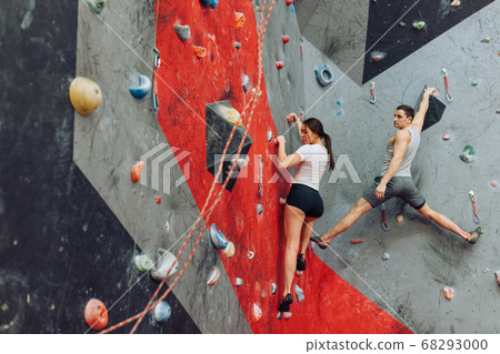 Rear view of woman climber and man instructor giving directions. 68293000