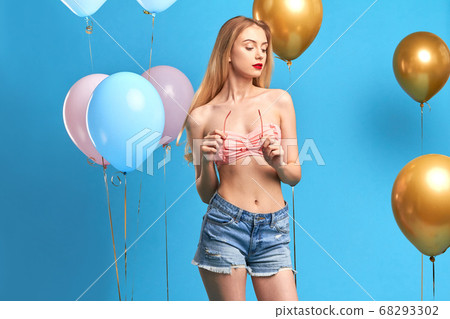 beautiful blonde girl holding sunglasses, looking down 68293302