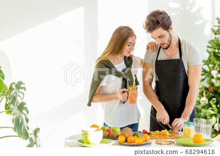 young couple are preparing a snack in the kitchen room young couple are preparing a snack in the kitchen room 68294618