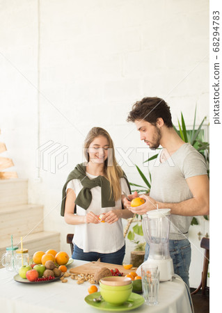 young nice people in stylish clothes are talking while preparing a dish 68294783