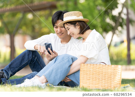 Young men and women enjoying a park date Young men and women enjoying a park date 68296534