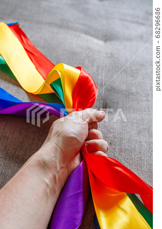 ribbon in lgbt rainbow flag color in male hand using how to celebrate homosexual, gay, lesbian and concept ribbon in lgbt rainbow flag color in male hand using how to celebrate homosexual, gay, lesbian and concept 68296686