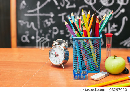 back to school concept, pencil holder, alarm clock on the background school board, university 68297020