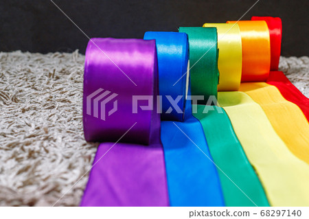 ribbons in the color of the lgbt rainbow flag in bobbins are rolled out on the carpet using how to celebrate homosexuals, gay, lesbian and concepts 68297140
