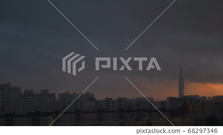 Lakhta Center in St. Petersburg at sunset, Rusia. Concept. High rise building surrounded by residential houses, business center on heavy sunset sky background, time lapse effect. Lakhta Center in St. Petersburg at sunset, Rusia. Concept. High rise building surrounded by residential houses, business center on heavy sunset sky background, time lapse effect. 68297346