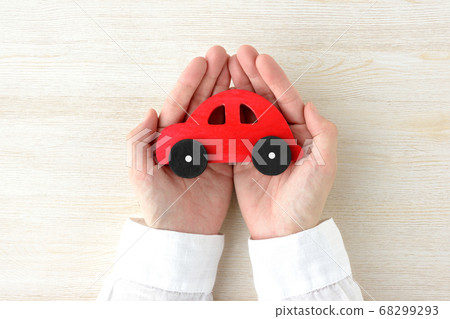 A car toy wrapped in the hands of a person 68299293