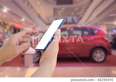 Hand hold blank screen smartphone with blurred background of car  show room for rent, buy, business, finance concept 68299345