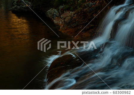 Amber water surface and waterfall flow Amber water surface and waterfall flow 68300982