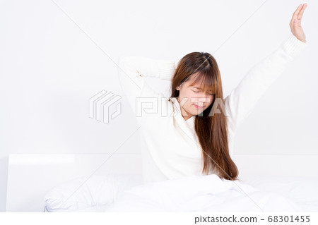 Young Asian woman stretching in bed after wake up 68301455