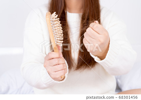 Hair fall problem, closeup hand holding comb and 68301456