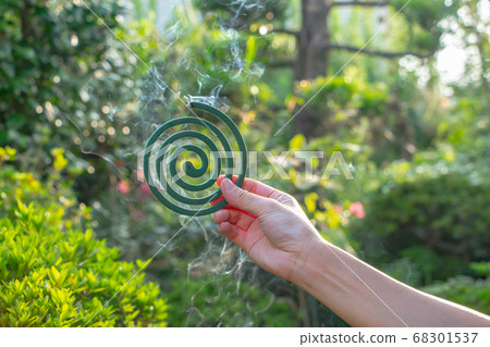 Smoke is coming out of the mosquito coil with my right hand 68301537