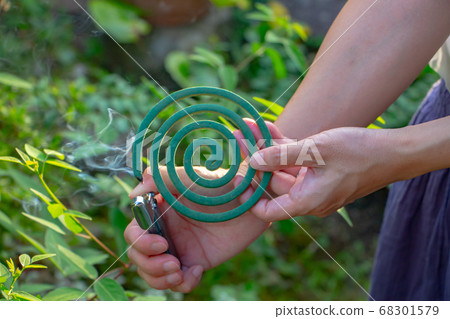 一名帶蚊香的女人用右手打火機點燃 68301579