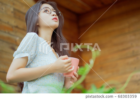 woman enjoying a cup of coffee in the morning woman enjoying a cup of coffee in the morning 68303359