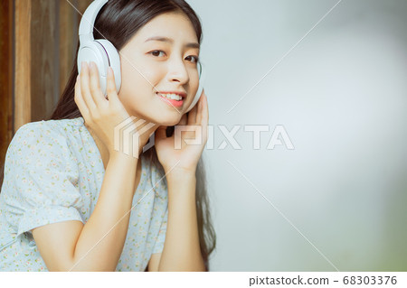 the woman is listening to music 68303376