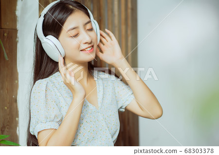the woman is listening to music 68303378