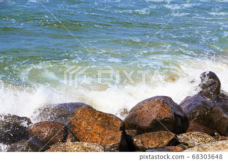 sea waves break on the rocks, a lot of spray. Sunny day. sea waves break on the rocks, a lot of spray. Sunny day. 68303648