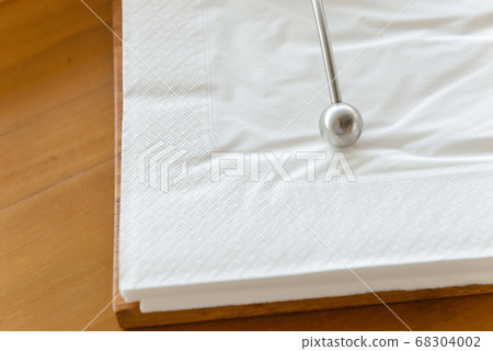 Metal paperweight on stack of white square paper napkin. modern paper napkin holder 68304002