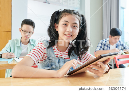 Schoolgirl working on tablet Schoolgirl working on tablet 68304574