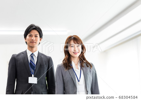 Male and female employees walking in the office Male and female employees walking in the office 68304584