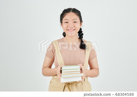 Schoolgirl with stack of books Schoolgirl with stack of books 68304589