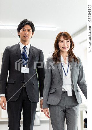 Male and female employees walking in the office Male and female employees walking in the office 68304593