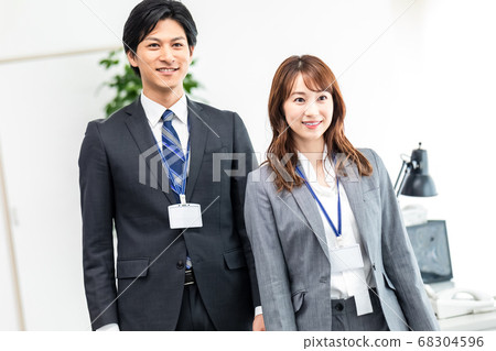Male and female employees walking in the office Male and female employees walking in the office 68304596