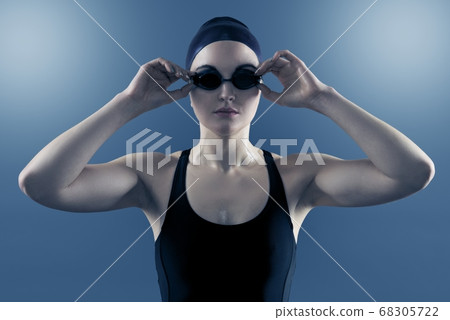 Studio portrait of woman swimmer with swimming goggles swimcap swimsuit 68305722