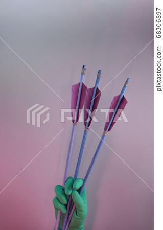 Beautiful hand holding old green arrows in the Beautiful hand holding old green arrows in the 68306897
