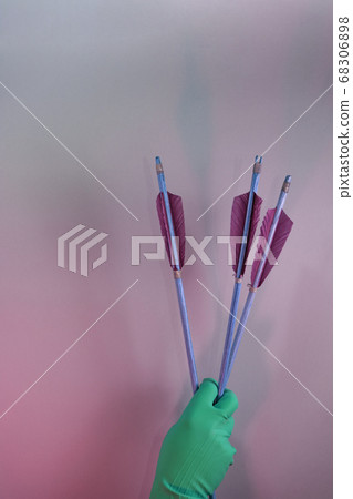 Beautiful hand holding old green arrows in the Beautiful hand holding old green arrows in the 68306898