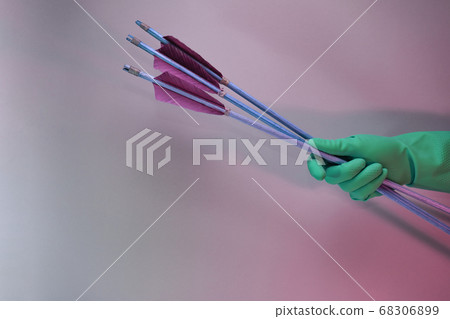 Beautiful hand holding old green arrows in the Beautiful hand holding old green arrows in the 68306899