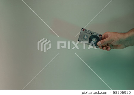 Hand holding audio cassette tape in the color 68306930
