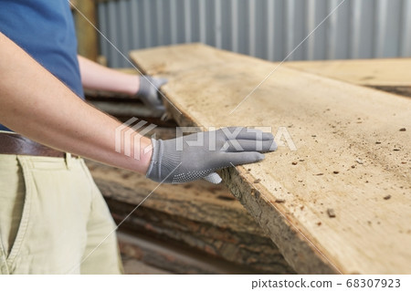 Carpenters hands with plank wood at carpentry woodworking workshop 68307923