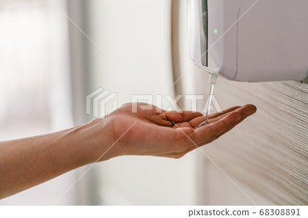 Closeup Asian woman hand using wash hand sanitizer gel dispenser automatic machine before work while Coronavirus Network Outbreak, health care and cleaning for prevent covid19 concept 68308891