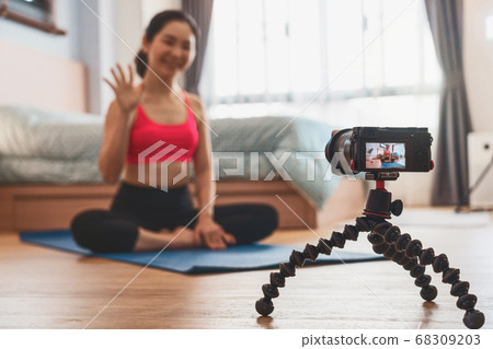 Camera taking video and live of Asian woman practicing yoga from home in bedroom when Covid19 outbreak, healthy or Meditation Exercise, coronavirus pandemic and quarantine,vlog and Influencer concept Camera taking video and live of Asian woman practicing yoga from home in bedroom when Covid19 outbreak, healthy or Meditation Exercise, coronavirus pandemic and quarantine,vlog and Influencer concept 68309203