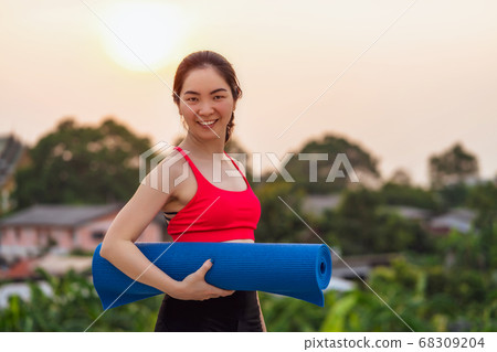Asian woman holding yoga mat from home at rooftop when Covid19 outbreak and lockdown, healthy or Meditation Exercise, yoga workout at home, coronavirus pandemic and quarantine, sports and healthcare Asian woman holding yoga mat from home at rooftop when Covid19 outbreak and lockdown, healthy or Meditation Exercise, yoga workout at home, coronavirus pandemic and quarantine, sports and healthcare 68309204