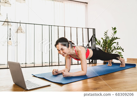 Asian woman practicing yoga from home with laptop when Covid19 outbreak and lockdown, healthy or Meditation Exercise, workout at home, coronavirus pandemic and quarantine,sports and healthcare concept Asian woman practicing yoga from home with laptop when Covid19 outbreak and lockdown, healthy or Meditation Exercise, workout at home, coronavirus pandemic and quarantine,sports and healthcare concept 68309206
