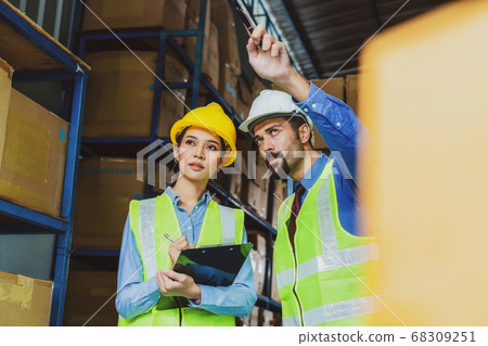 Manager of warehouse worker assign and command in serious look to assistant manager woman in local warehouse or factory, Asian and white caucasian people,Partner and colleague working together concept 68309251