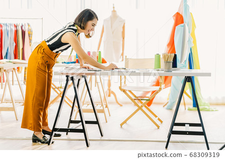 Young Asian designer woman working with computer and choosing multicolor chart at workplace, small business startup, Business owner entrepreneur, modern freelance job lifestyle concept. asia people Young Asian designer woman working with computer and choosing multicolor chart at workplace, small business startup, Business owner entrepreneur, modern freelance job lifestyle concept. asia people 68309319