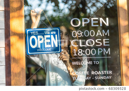 Closeup Asian young asian woman setting open sign at the shop glasses for welcome the customer in to the coffee shop, small business owner and startup with cafe shop, installing open and close concept 68309328