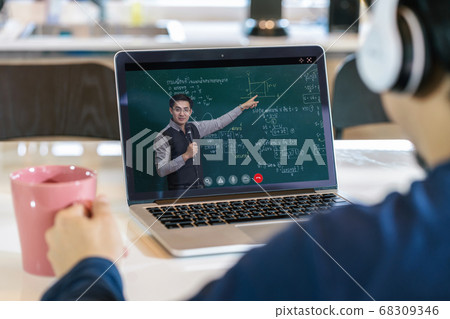 Rear View of Asian student learning with teacher over the physics formular in thai laguage on black board via video call conference when Covid-19 pandemic, education and Social distancing concept 68309346