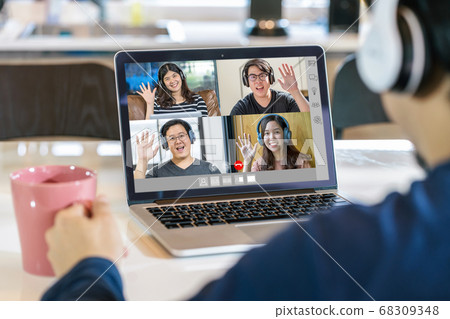 Rear View of Asian Business man say hello with teamwork colleague in video conference when Coronavirus outbreak, Covid-19 pandemic,headphone and online meeting,Social distancing and new normal concept 68309348