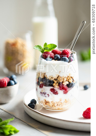 Glass of parfait made of granola, berries and yogurt. Glass of parfait made of granola, berries and yogurt. 68309718
