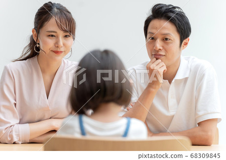 Parent and child having a family meeting in the living room 68309845