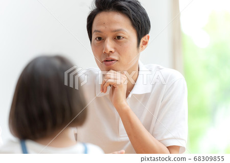Parent and child having a family meeting in the living room 68309855