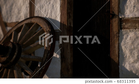 old wood wheel and black door at white house old wood wheel and black door at white house 68311395