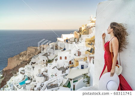 Europe Greece Santorini travel vacation woman on famous santorini Oia island travel destination. Happy young tourist woman. Summer wanderlust. Europe Greece Santorini travel vacation woman on famous santorini Oia island travel destination. Happy young tourist woman. Summer wanderlust. 68311741