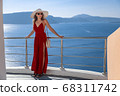 young woman enjoying view of Santorini, Greece 68311742