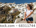 Happy smiling woman tourist traveling on luxury cruise in Mediterranean, Greece, Santorini. Background architecture island sea sky 68311744