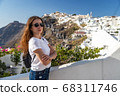 Happy smiling woman tourist traveling on luxury cruise in Mediterranean, Greece, Santorini. Female with folded arms, background architecture island sea sky 68311746