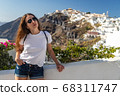 Happy smiling woman tourist traveling on luxury cruise in Mediterranean, Greece, Santorini. Background architecture island sea sky 68311747